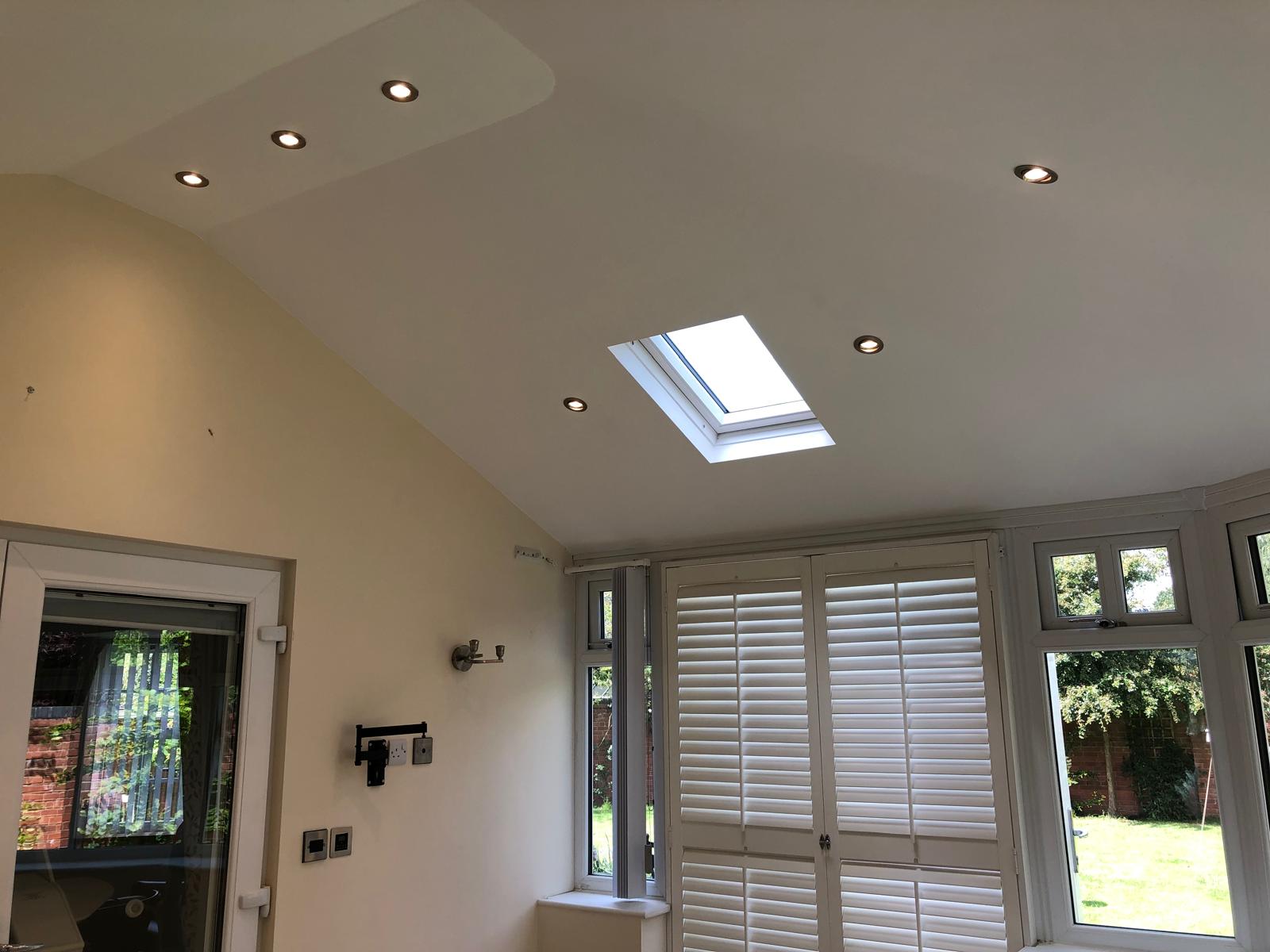 Plastered vaulted conservatory ceiling with recessed downlights and Velux skylight